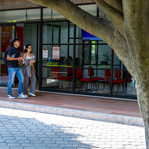 Alumnos caminando fuera de Becas y Caja